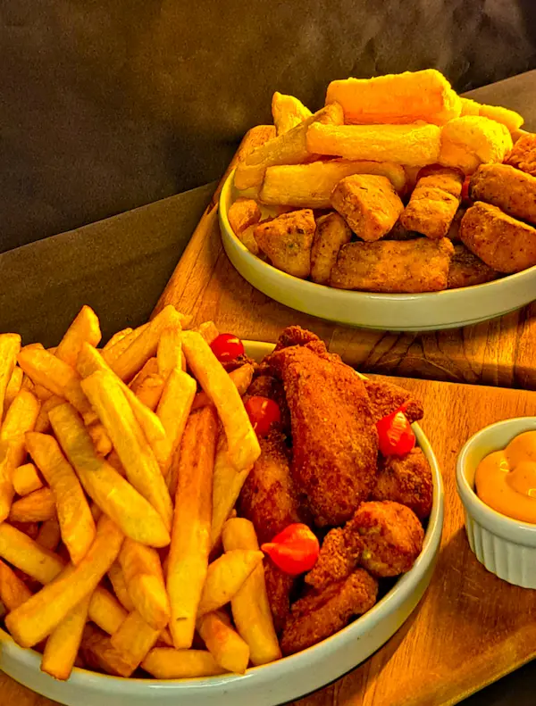 Porção de frango frito com batata e mandioca frita do Mugs Germânia