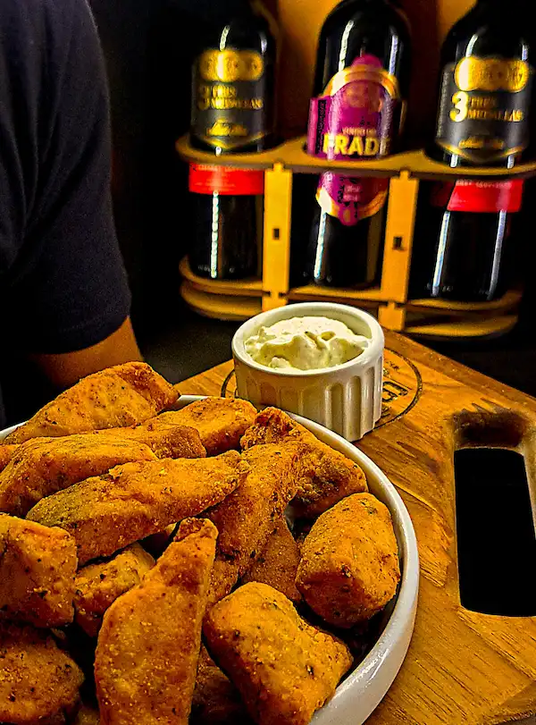 Porção de peixe frito com crosta dourada no Mugs Germânia
